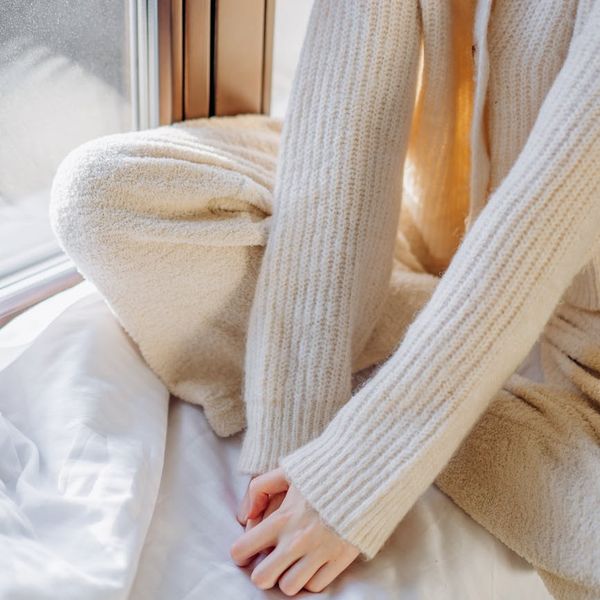 Person stretching gently near a window with morning light.